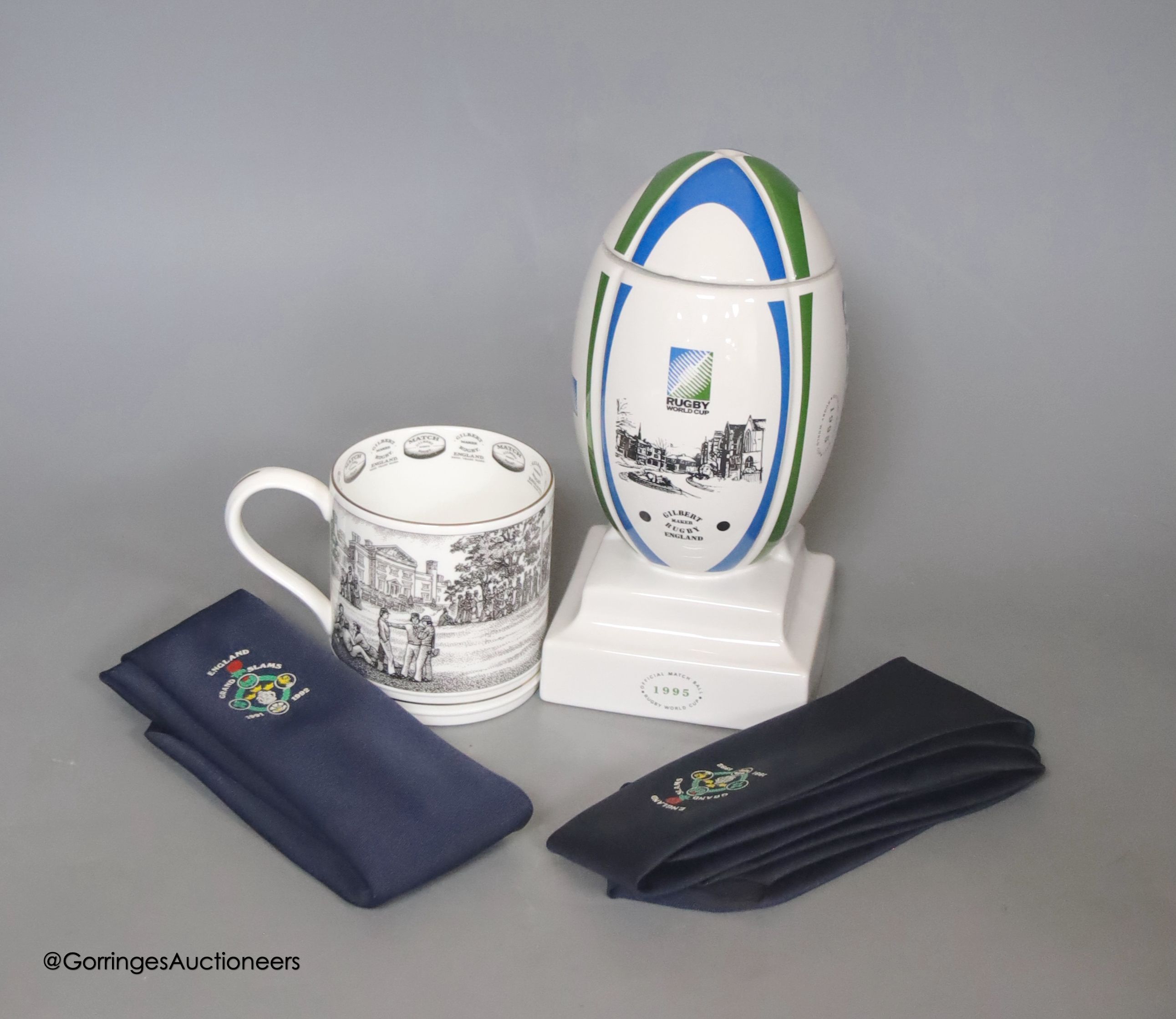 A Wade porcelain Gilbert Rugby ball box and cover, together with two Grand Slams 1991 and 1992 ties, and a Wedgwood Gilbert Rugby mug produced specially for The James Gilbert Rugby Football Collection, limited edition of